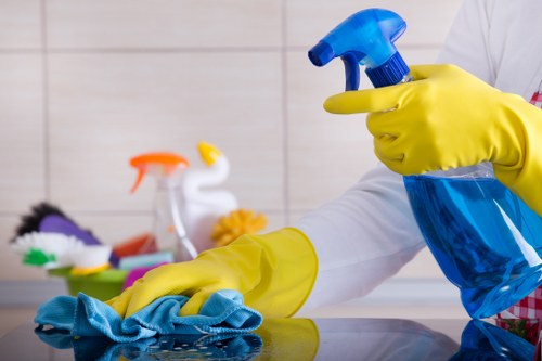 Technician treating a fabric sofa with upholstery cleaning equipment